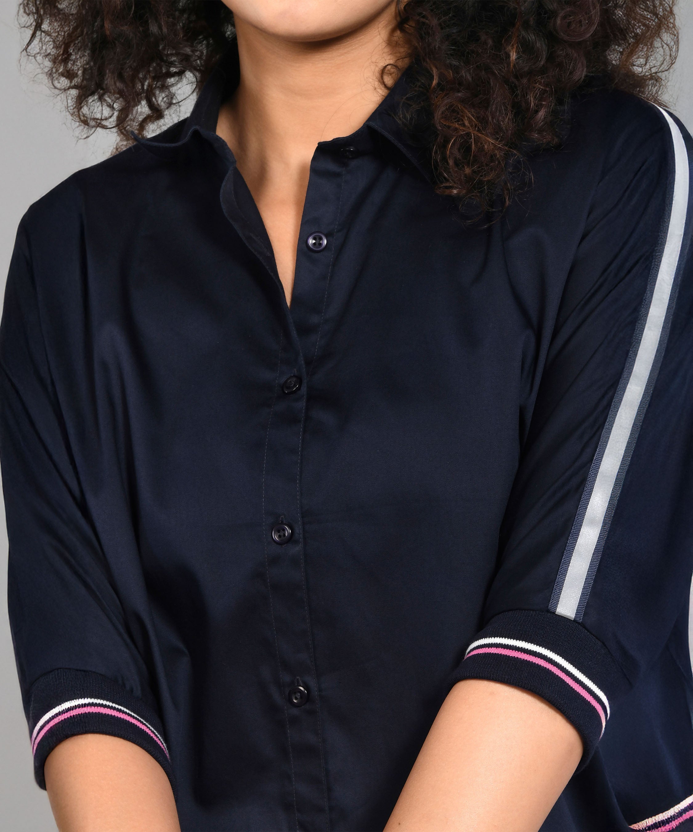 Woman wearing the Navy Blue Chic Set, featuring a navy blue top with batwing sleeves and striped details, shown from shoulders to waist.