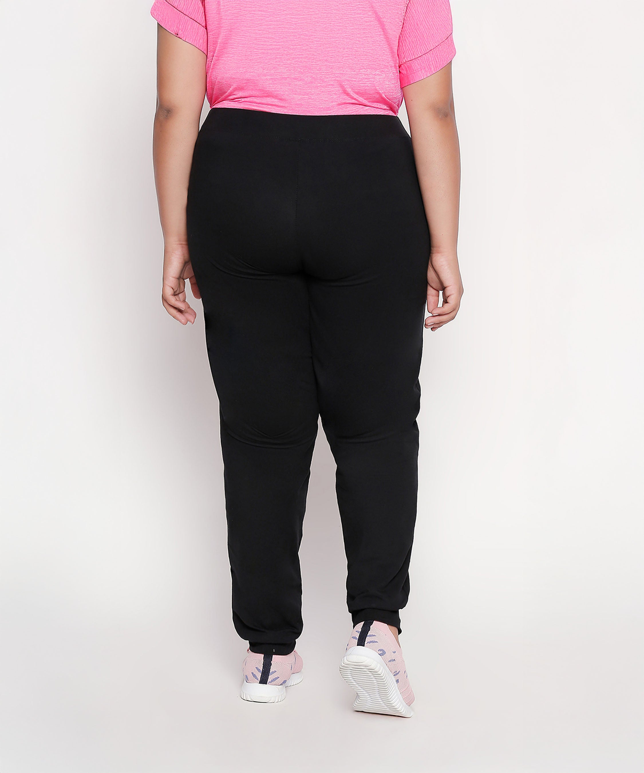 Model in a pink shirt and Classic Joggers - Plus Size 02, paired with pink sneakers, shown from the back against a plain background.