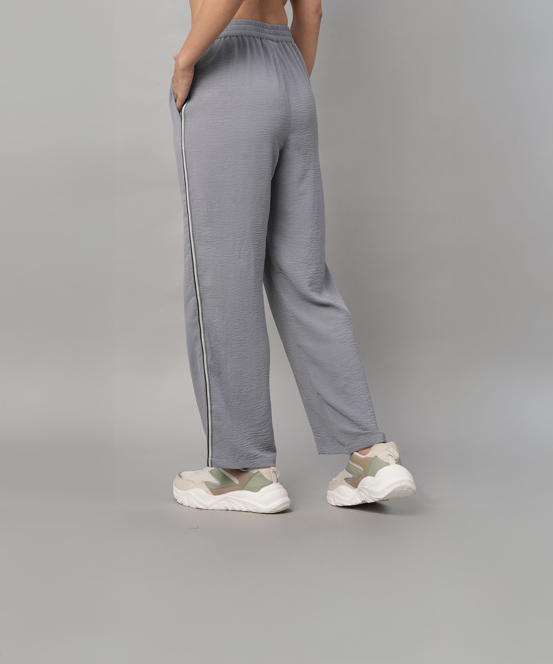 Person wearing the Grey Tie Up Top with Loose Pants Cord Set, featuring loose gray pants with a white side stripe and white sneakers, shown from the back.