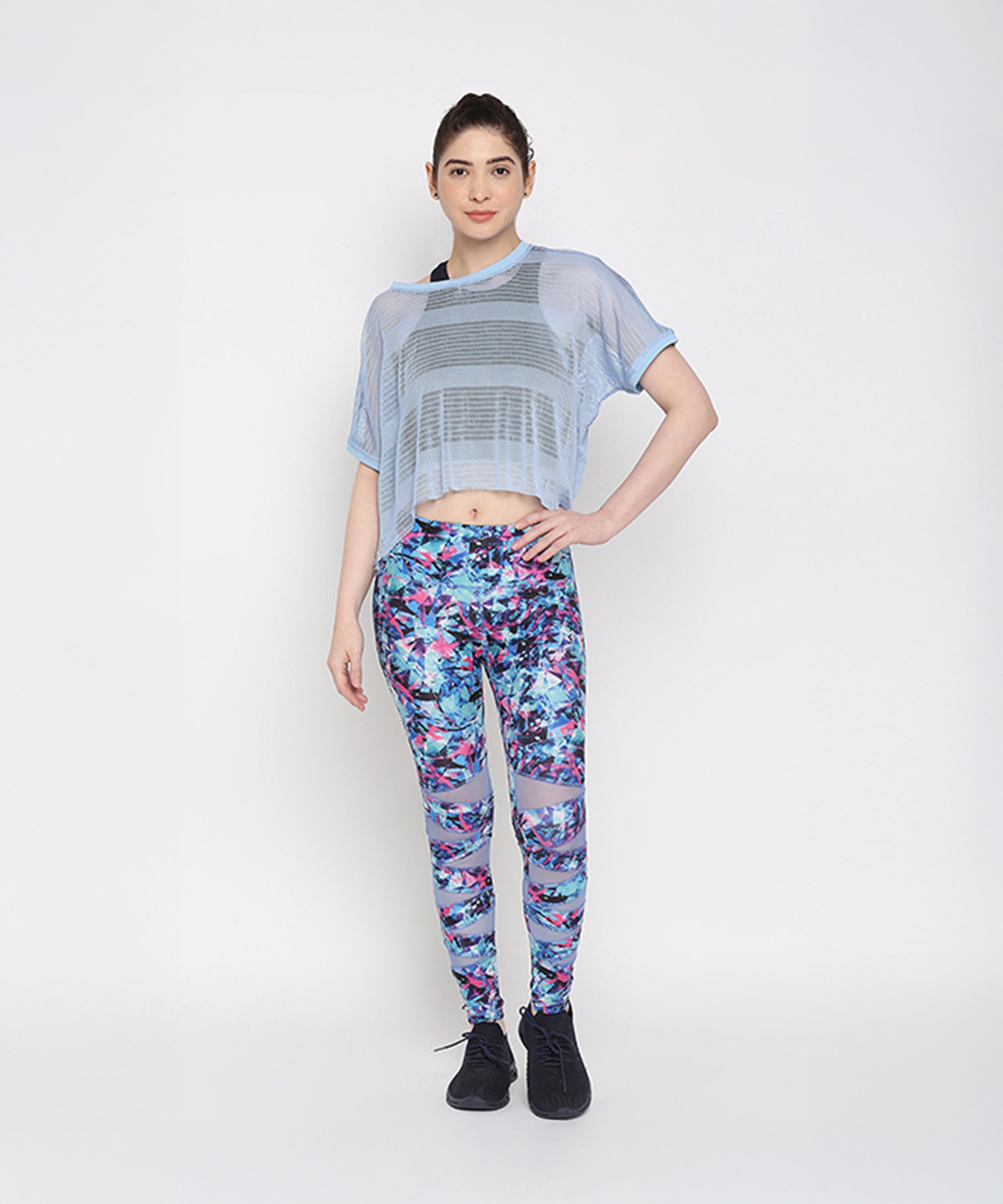 Woman wearing the Blue Netted Top and stylish leggings poses against a plain white background, highlighting a trendy sporty look.