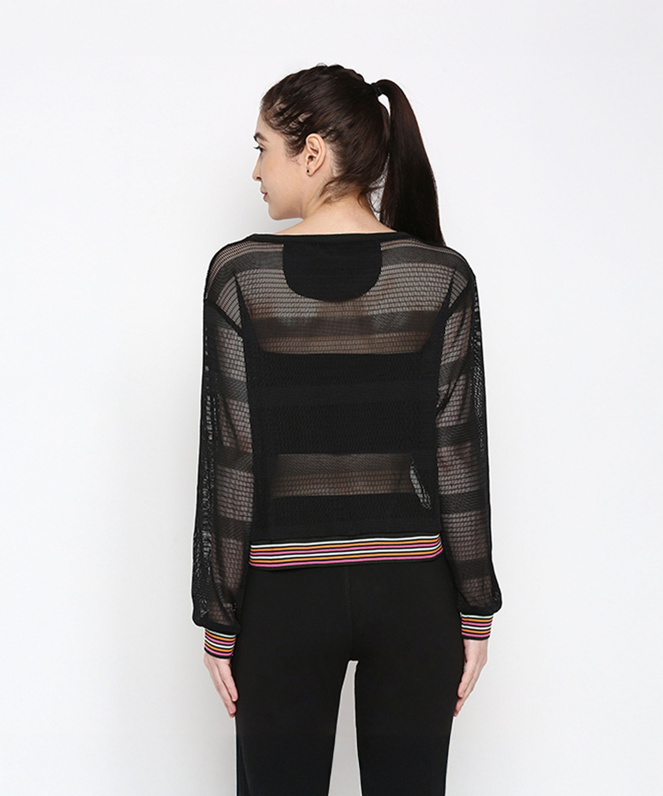 A woman shown from behind wears a sporty Black Netted Top with striped cuffs and waistband, paired with black polyblend pants.