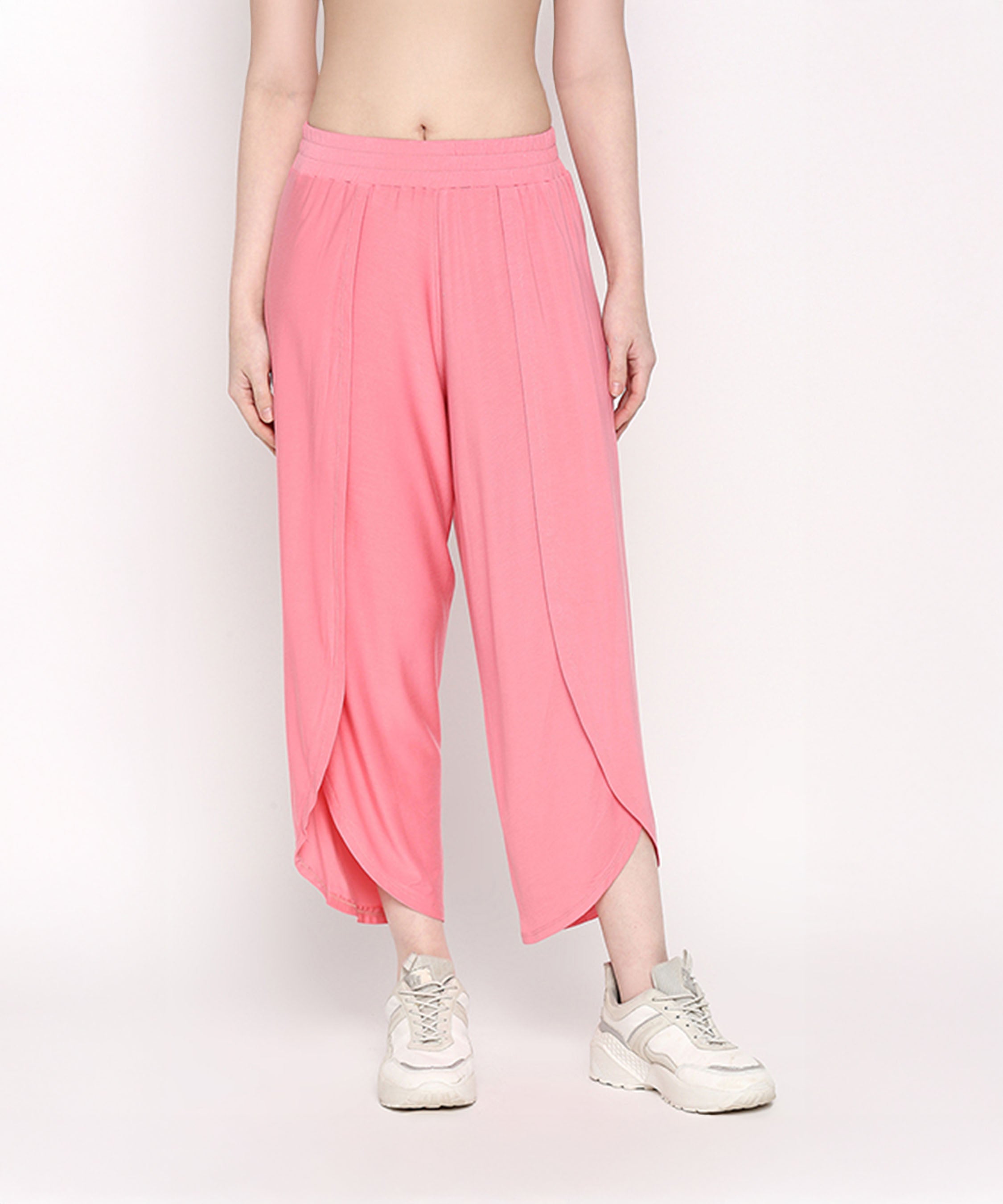 A person wearing the Coral Blissful Tulip Set, made from soft Cotton Modal, paired with white sneakers and standing against a plain light background.