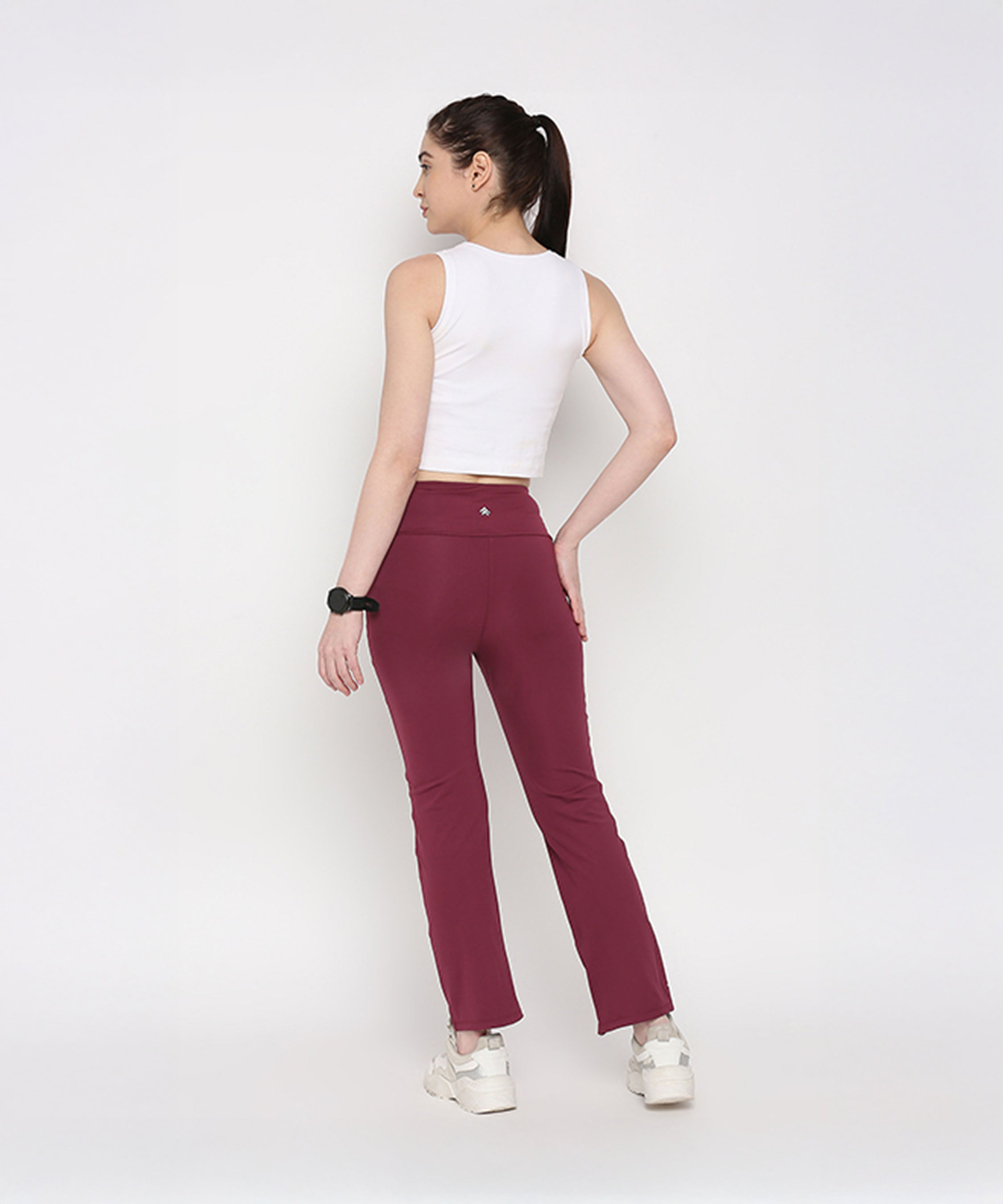 Woman wearing a White Twisted Crop Top and maroon pants, standing with her back to the camera.