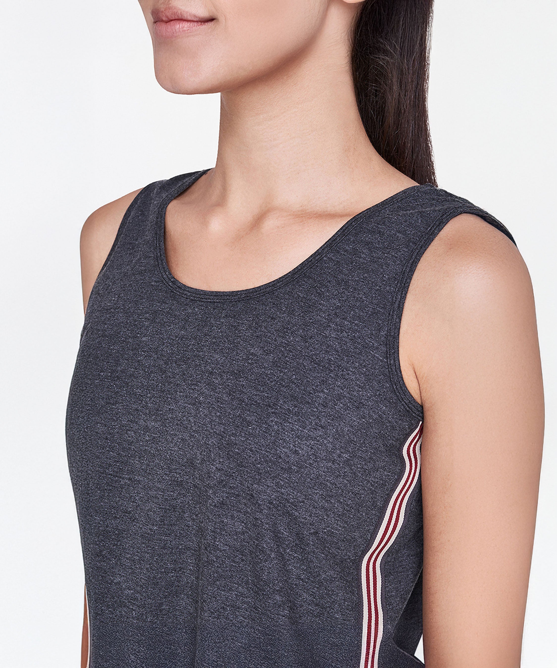 A woman, shown from the shoulders up, wears a Grey Sleeveless Tank Top featuring red and white side stripes.