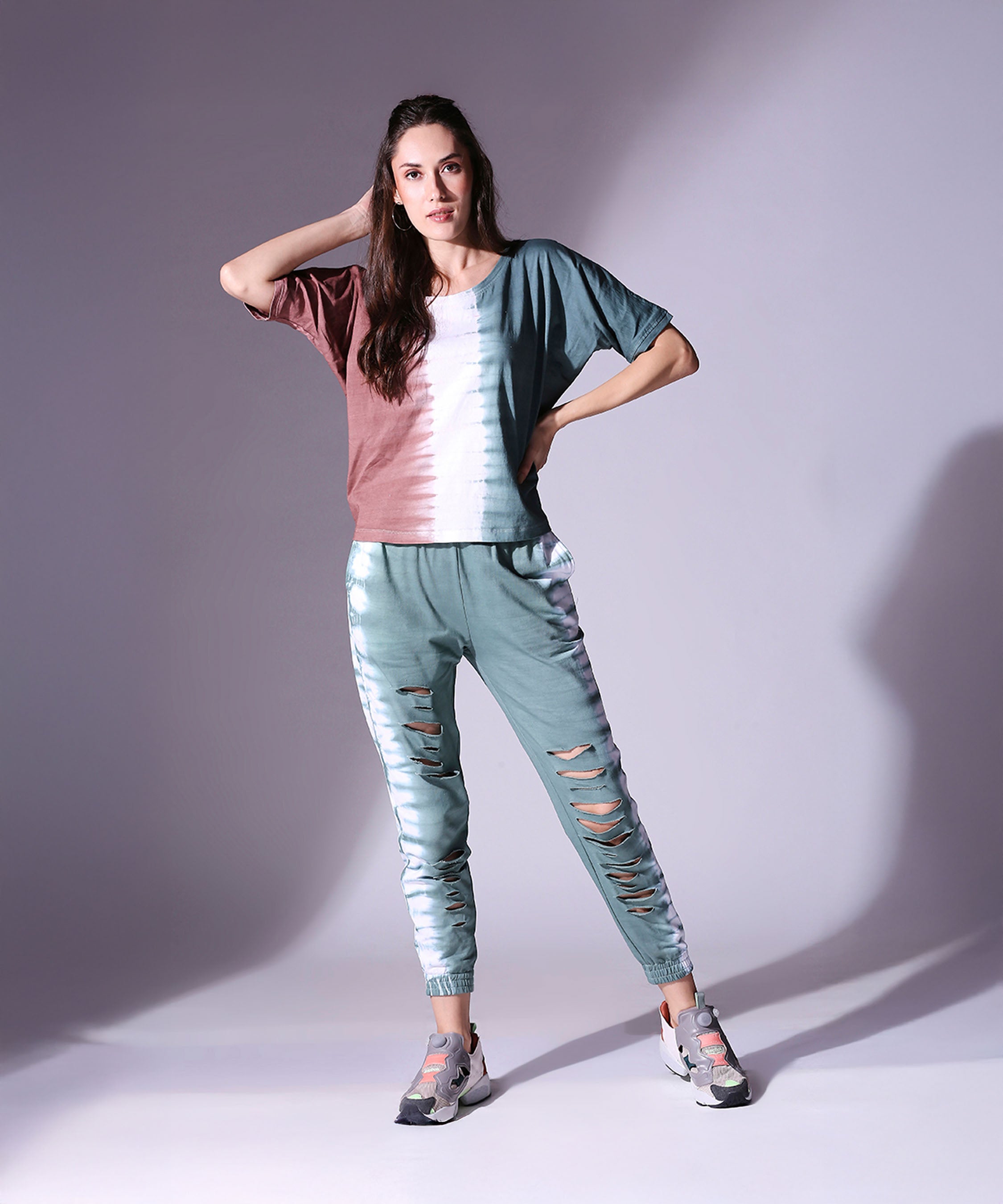 A woman poses in the Comfort Fit Tie Dye Top + Ripped Tie Dye Joggers - AW21, capturing the essence of autumn-winter style.