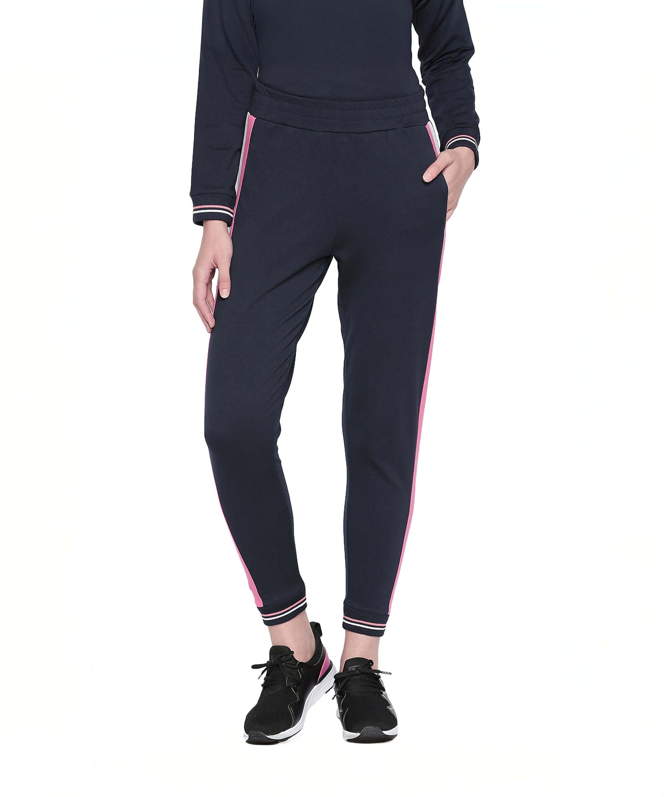Wearing Navy Blue Joggers with Side Stripe and black sneakers, this look is ideal for women’s active wear during any sports activity. Shown here against a white background.