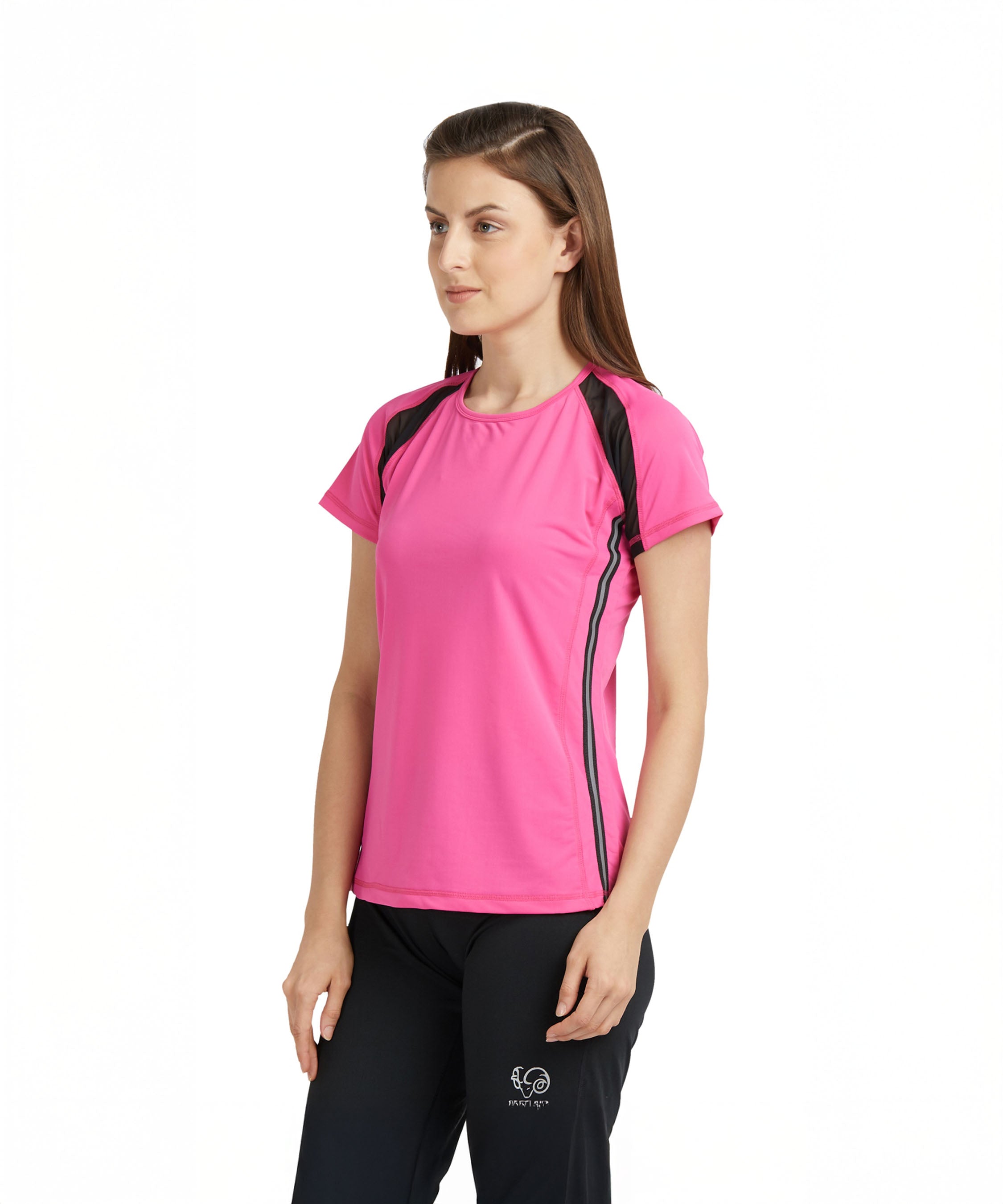 A woman wears a Tuna London Pink Poly Blend Round Neck Women’s T-Shirt with black pants, standing against a white background.