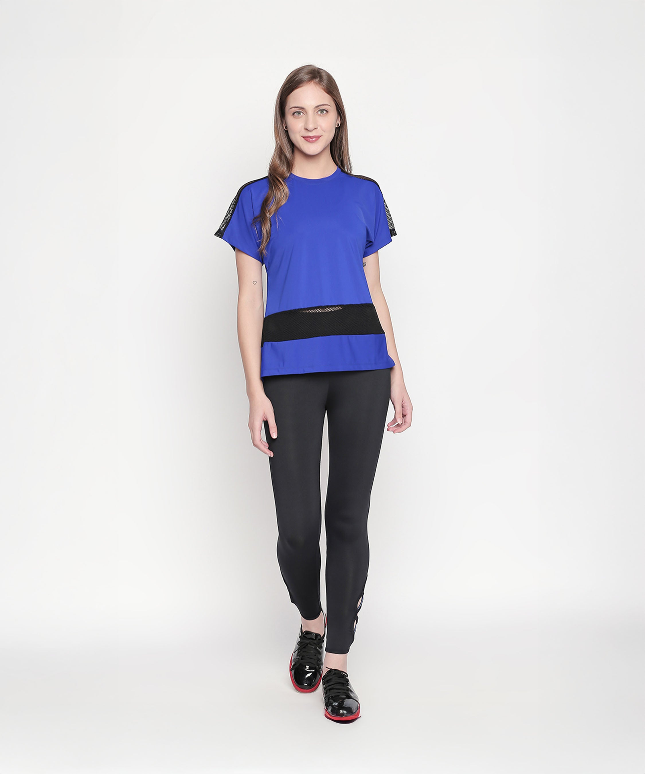 Woman in a blue top and Tuna London Black Color Tight Fit Women’s Leggings, standing and smiling against a plain white background.