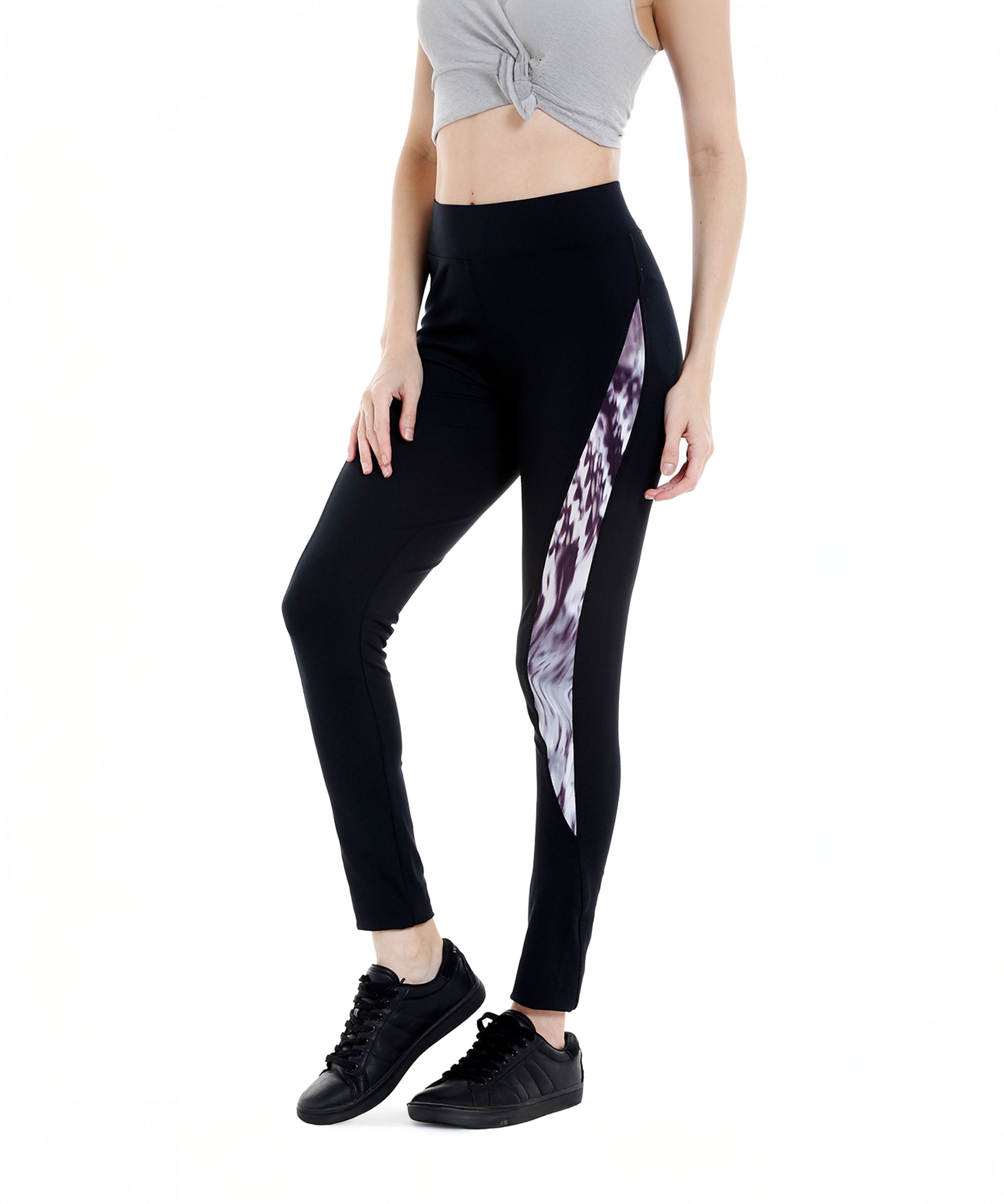 Woman in a grey crop top and Black Sports Leggings G2 with a patterned side panel and an elasticated waistband, paired with black sneakers.