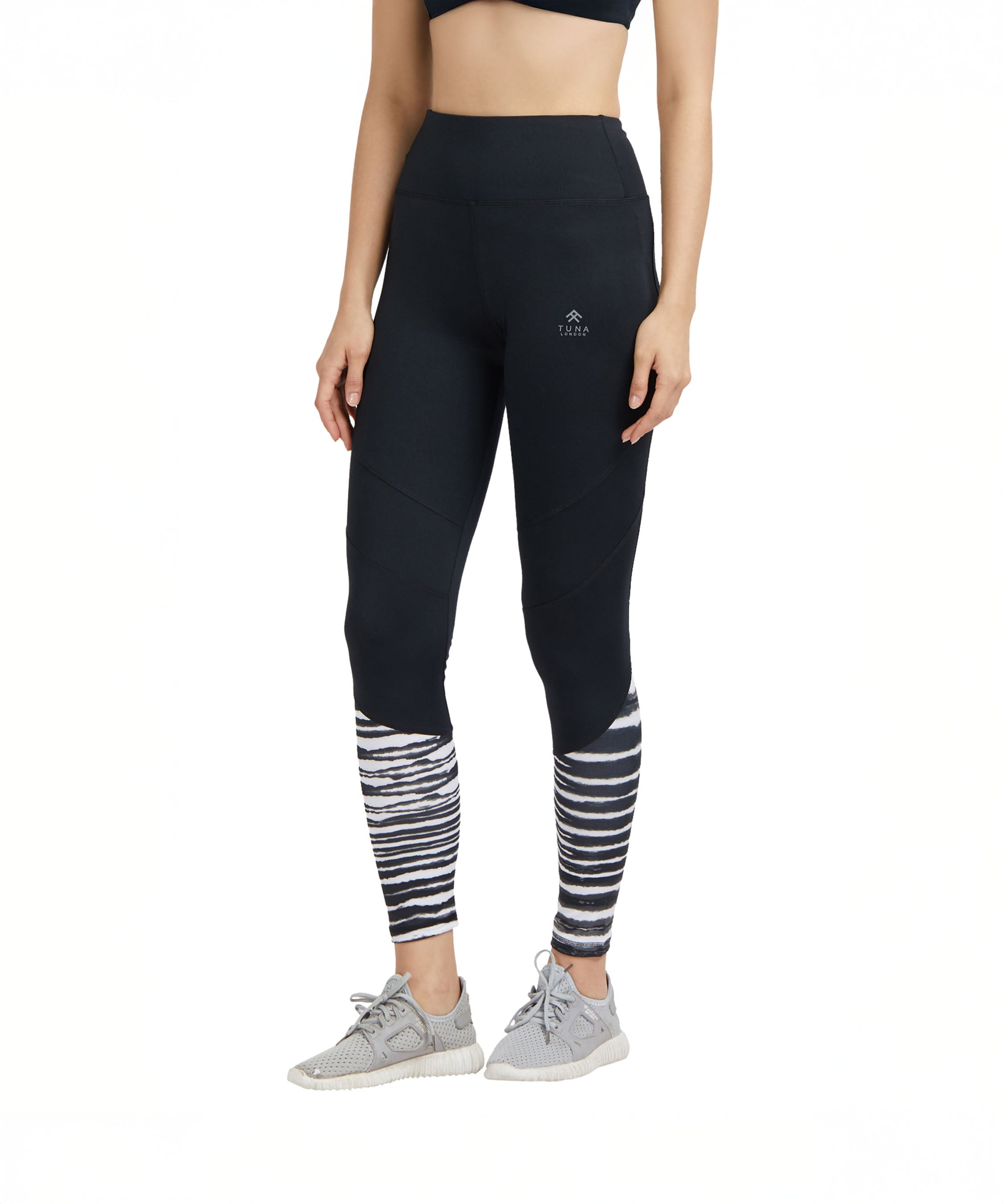 Woman wearing Black High Waisted Compression Sports Leggings With Zebra Print paired with gray sneakers and a black crop top.