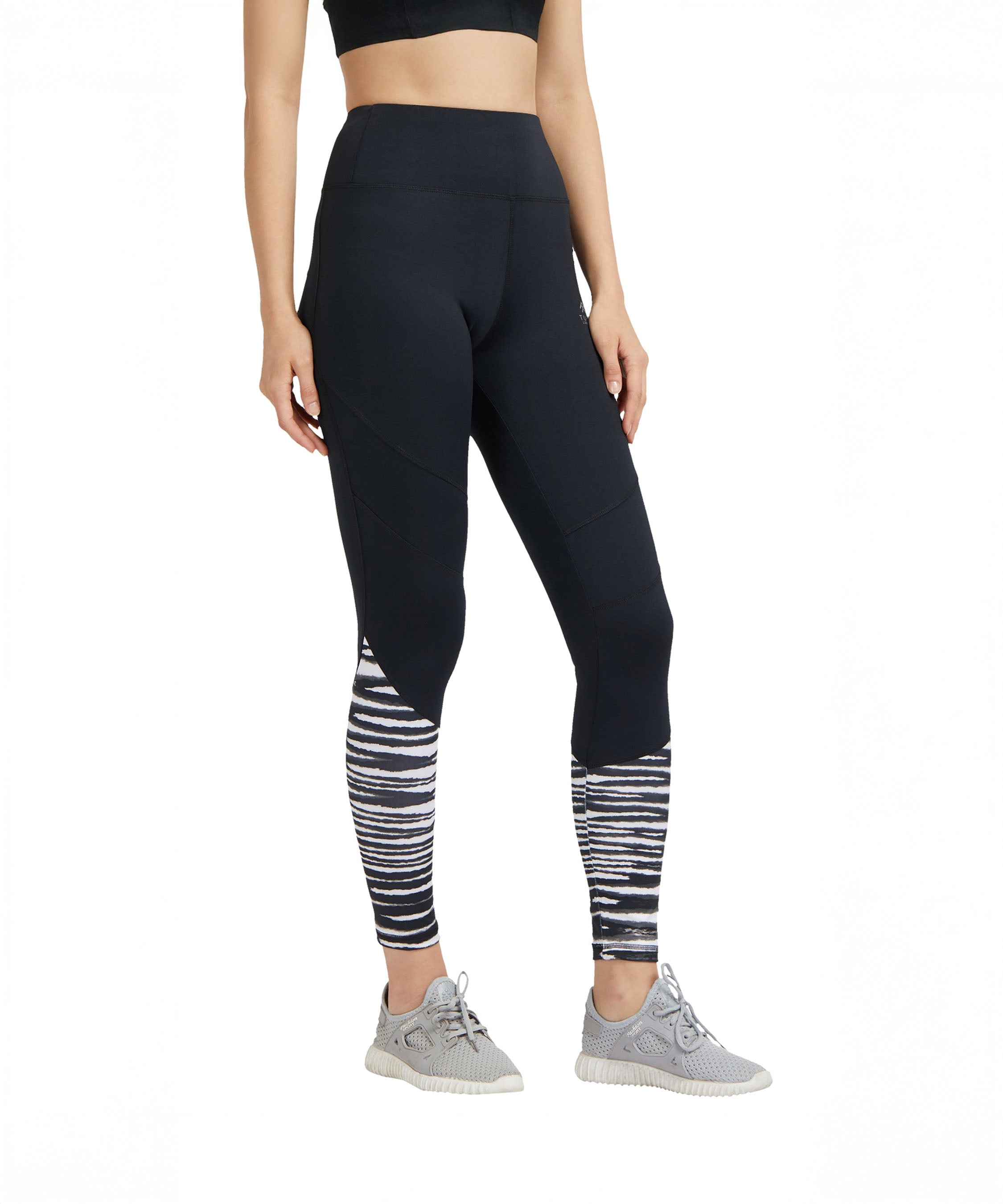 Woman wearing Black High Waisted Compression Sports Leggings With Zebra Print, paired with gray sneakers and a black crop top.