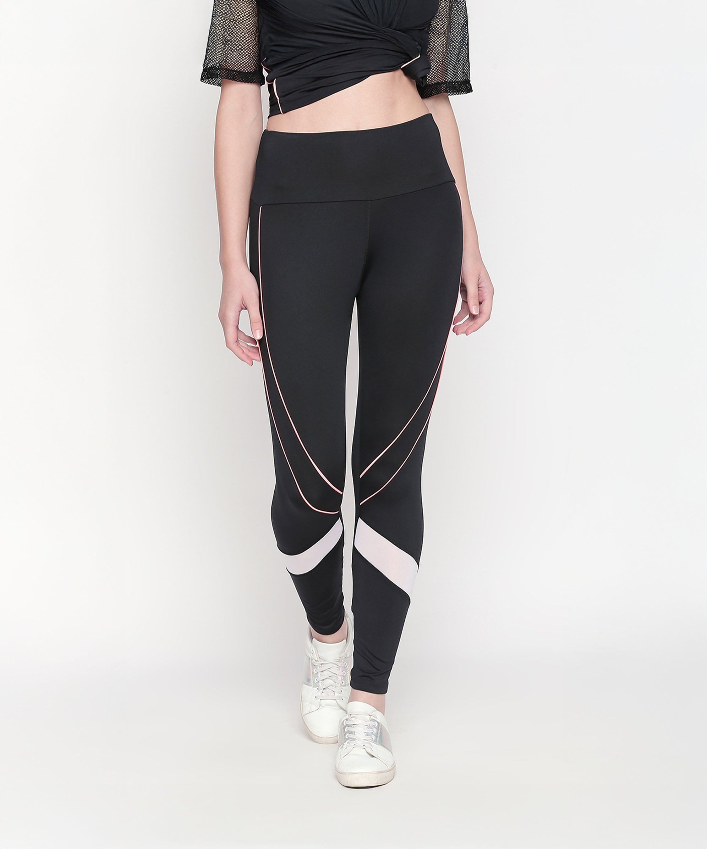 A woman wears the Activewear Black Tracksuit—high-waisted leggings with white and pink accents, paired with white sneakers. The moisture-wicking fabric makes it ideal for workouts.