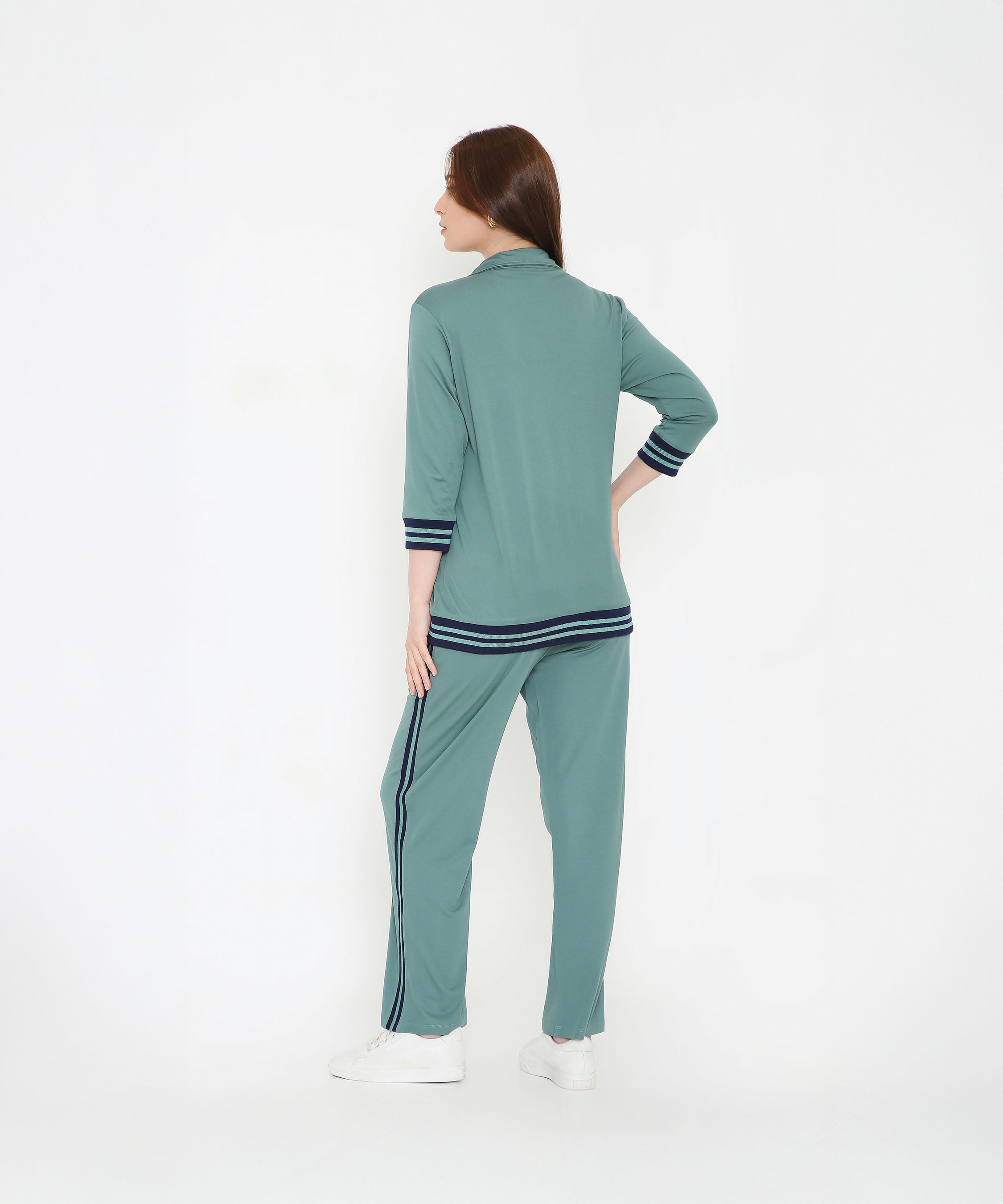 Woman wearing the Sage Green Athleisure Blazer Jacket and Track Set with black stripes, standing and facing away on a white background.