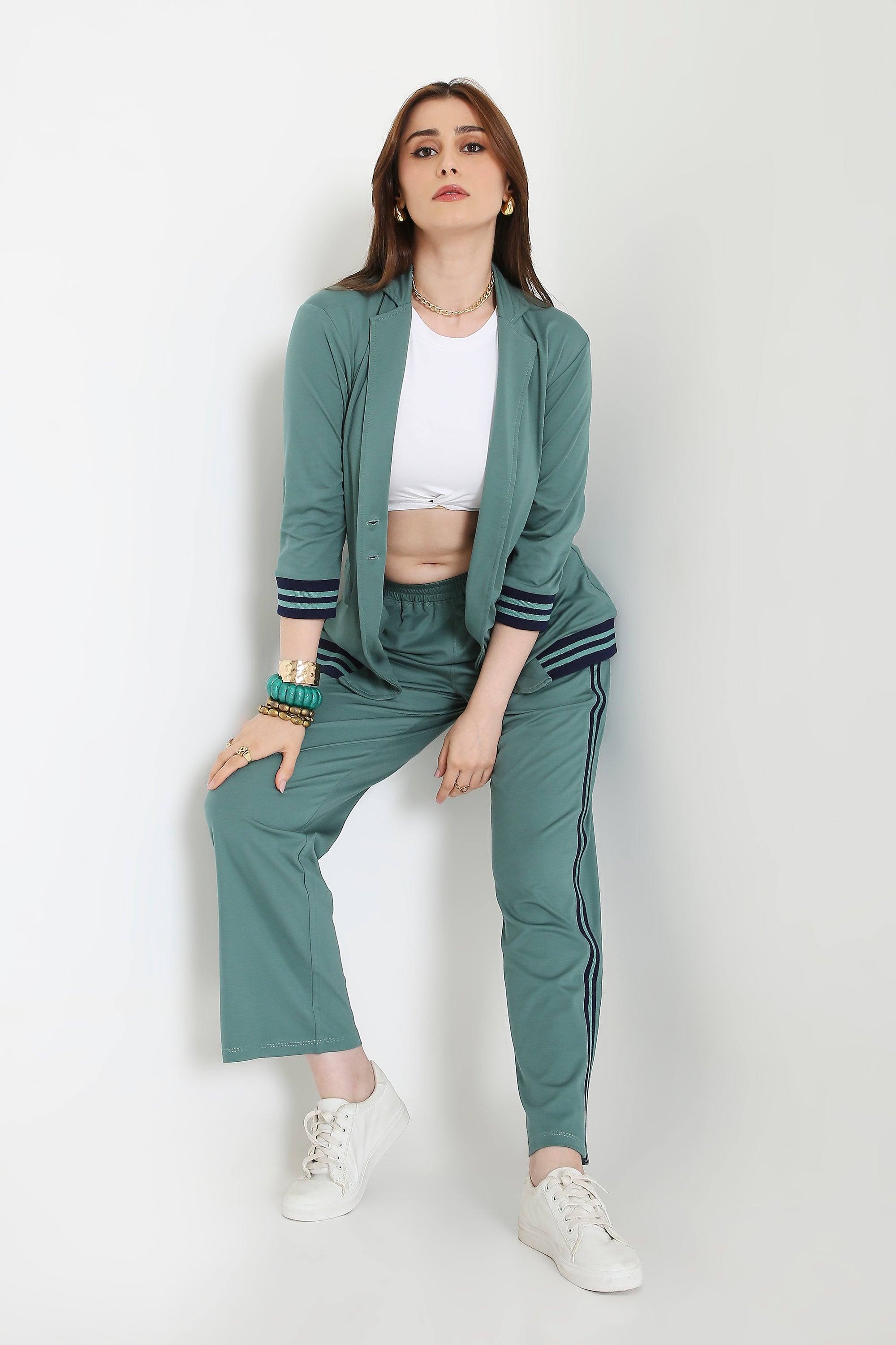 Woman wearing the Sage Green Athleisure Blazer Jacket and Track Set with a white crop top and sneakers, posing against a plain white background.