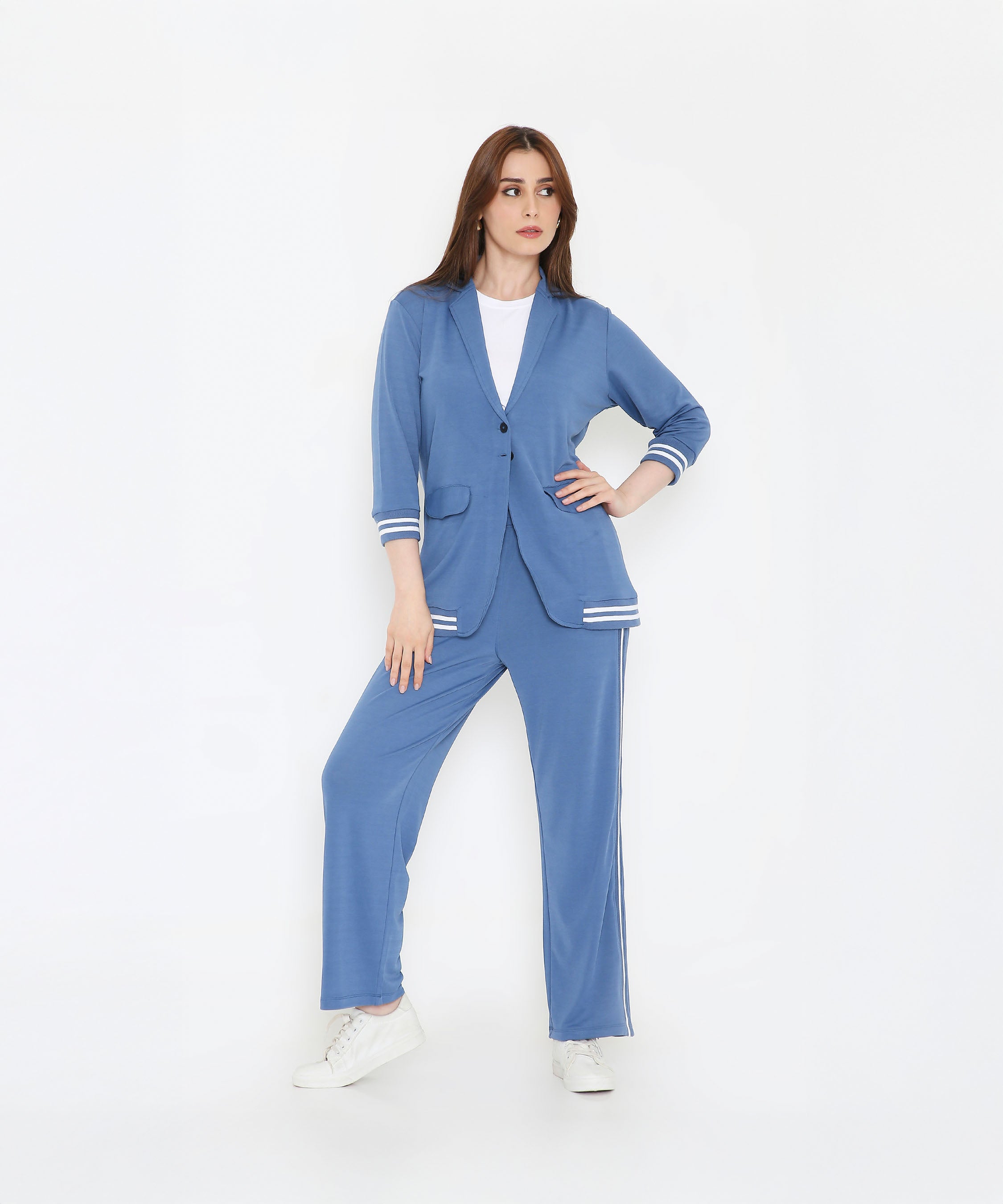 Woman wearing the Atlantic Blue Athleisure Blazer Jacket and Track Set with white stripes, paired with white sneakers, standing against a plain white background.