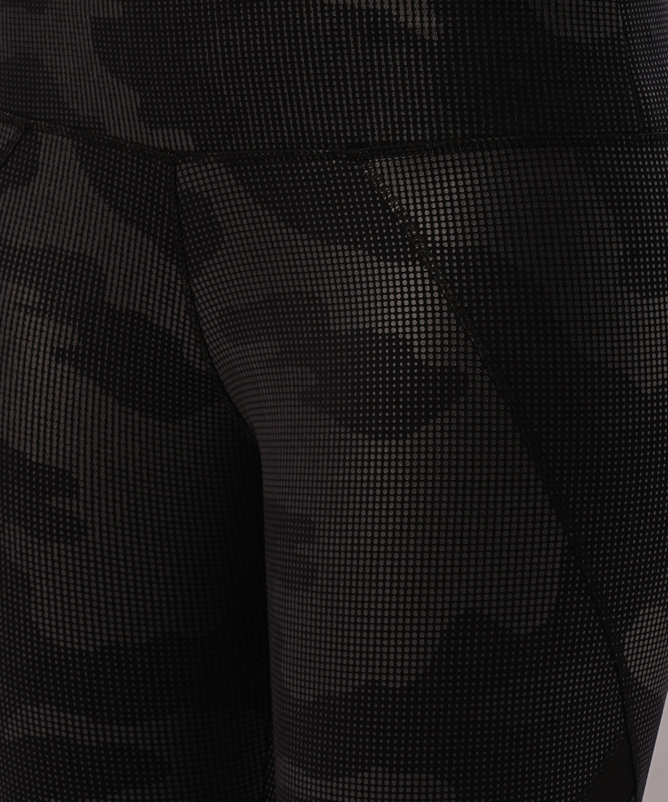 Close-up of Metallic Leggings featuring black textured fabric, a subtle camouflage pattern, visible stitching, and a stylish statement vibe.