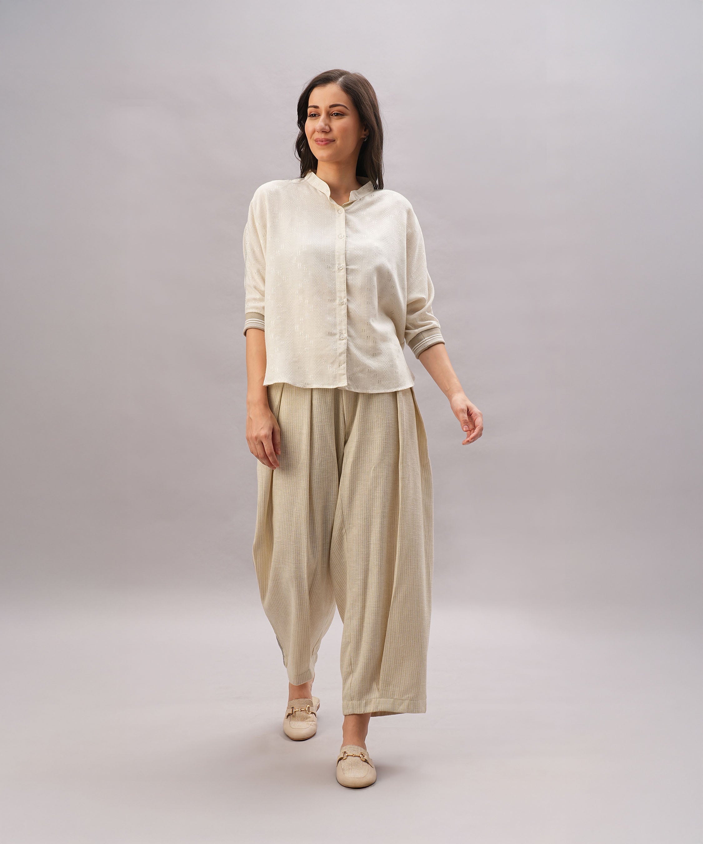 A woman models the Beige Linen Set, featuring a relaxed-fit shirt and wide-legged pants made from breathable linen, against a plain background.