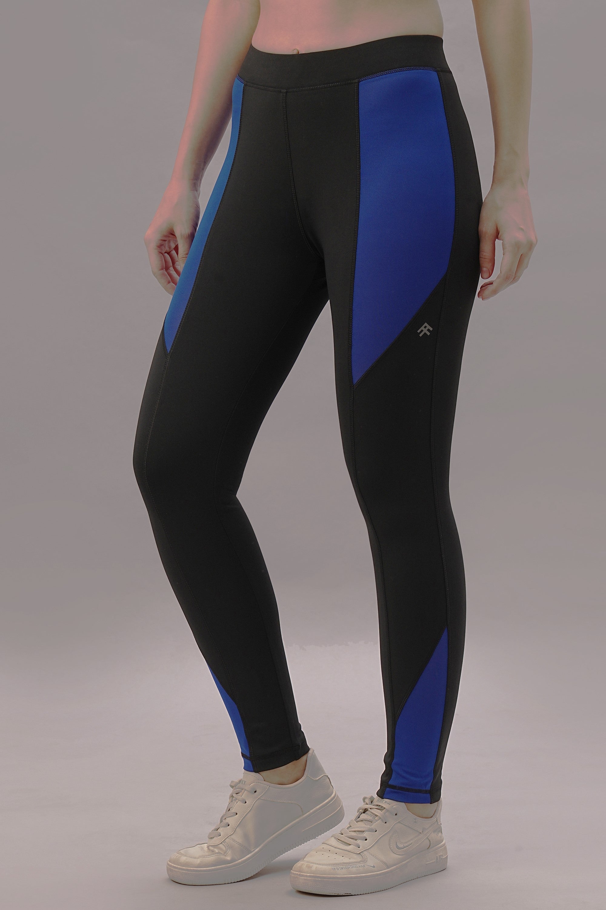 A person models Black and Blue Pants with white sneakers, standing against a plain background.