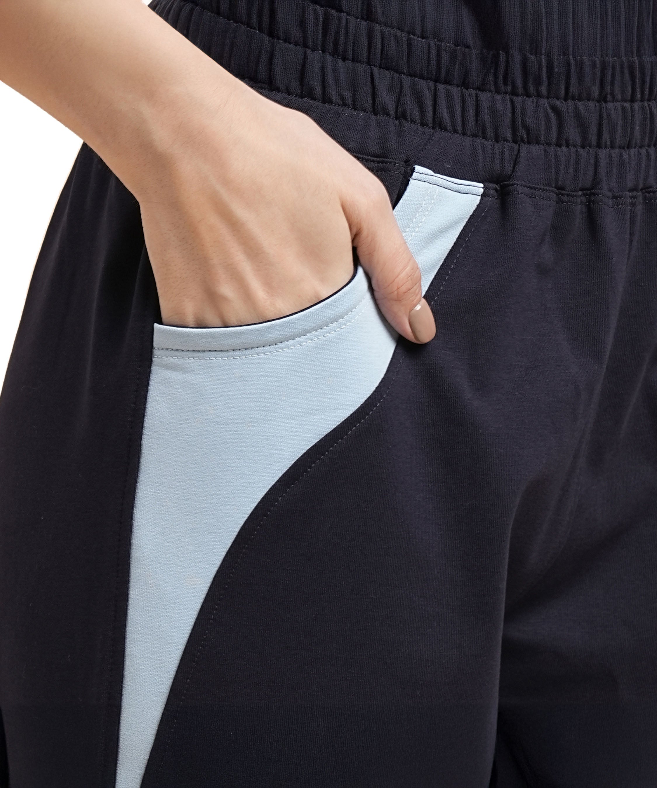 A hand rests in the pocket of Tuna Active Navy Blue Joggers, which feature a skin-friendly fabric and a light blue accent.