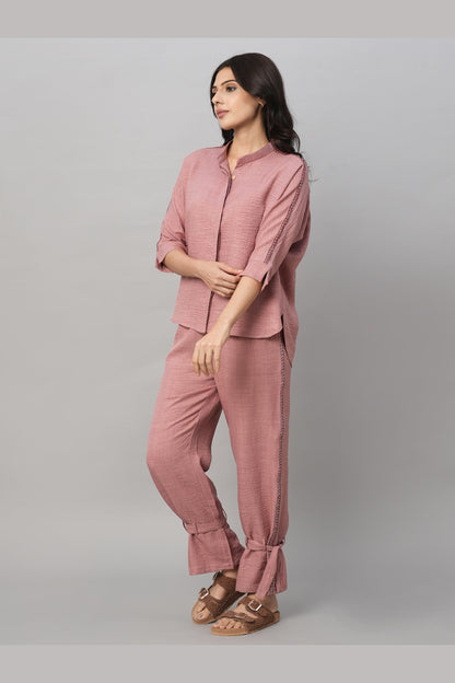 A woman stands against a gray background wearing the Vintage Pink Loose Shirt and Tie Up Pant Cord Set made from 100% cotton, paired with sandals.