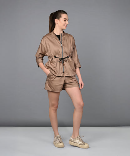 A woman wearing the Zipped Neutral Jacket Shorts Set smiles against a plain gray background.
