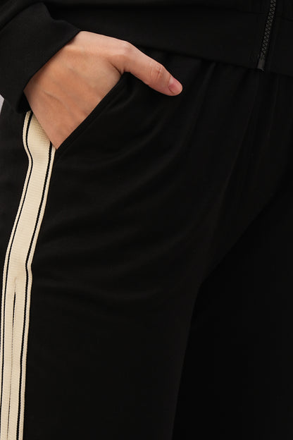 Close-up of a hand in the pocket of Black Co-Ord Set pants with a white side stripe, ideal for pairing with your favorite top or styling as part of a coordinated outfit.