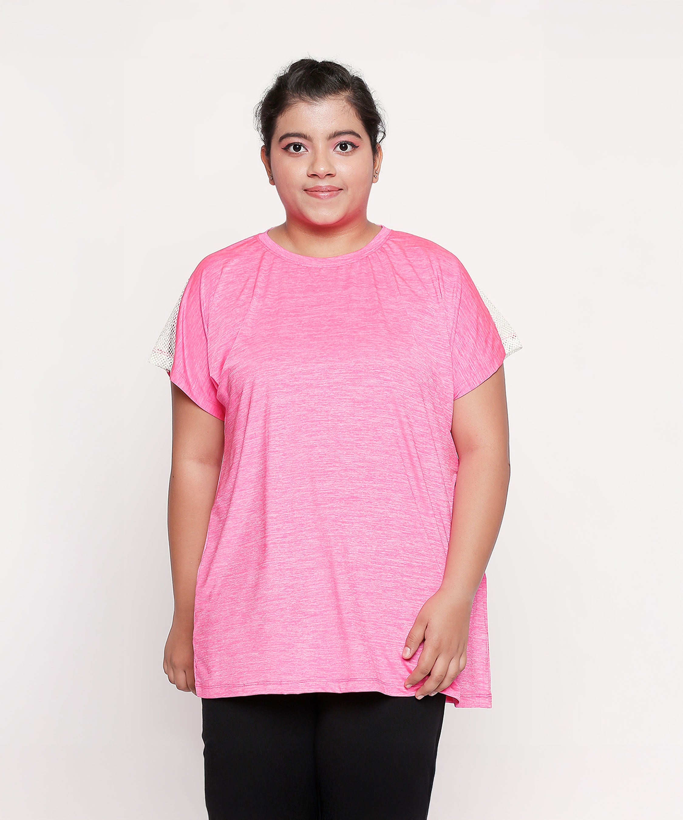 Woman wearing the Nova Sports Tee in pink with black pants, standing against a plain white background—a perfect pick for your workout wardrobe.
