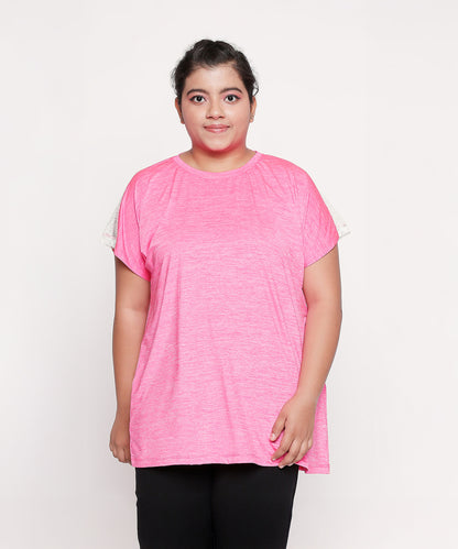 Woman wearing the Nova Sports Tee in pink with black pants, standing against a plain white background—a perfect pick for your workout wardrobe.