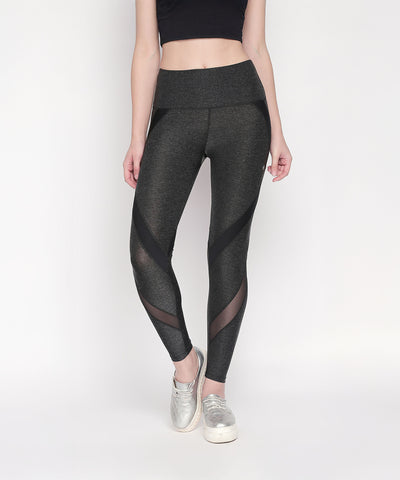 A woman wears Grey High Waisted Sports Leggings LG14 with mesh panels and a black crop top, standing against a white background.