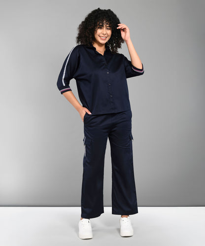 Person with curly hair wearing the Navy Blue Chic Set and white sneakers, standing and smiling.