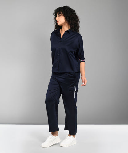 A woman wears the Navy Blue Chic Set—a navy co-ord with a batwing sleeve shirt and matching pants—standing against a plain gray background.