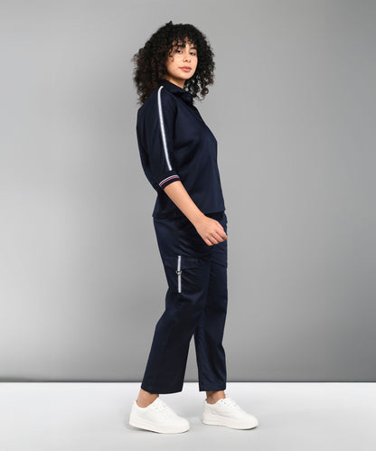 A woman models the Navy Blue Chic Set with white sneakers, posed sideways against a grey backdrop.