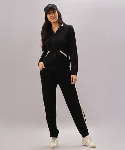 A woman wearing the Black Co-Ord Set pairs it with white sneakers and a black cap, smiling against a plain background to showcase this stylish coordinated outfit.