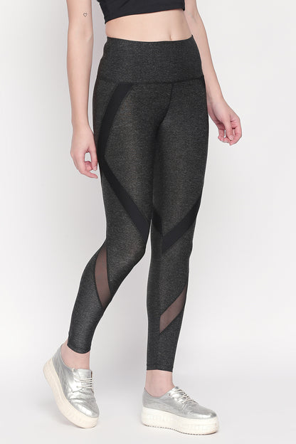 Woman wearing Grey High Waisted Sports Leggings LG14 with black mesh panels, silver sneakers, and a black crop top for ultimate workout comfort.