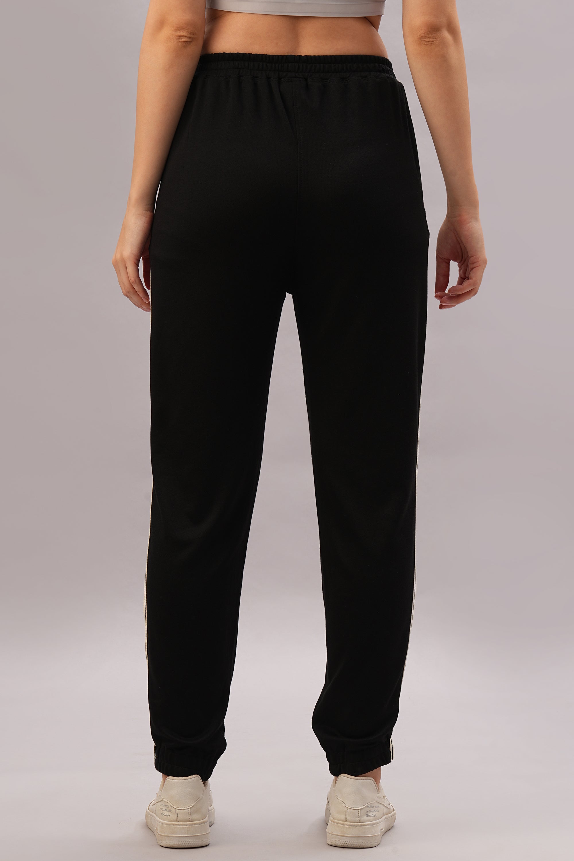 Model showcases the Black Co-Ord Set from the back, paired with white sneakers against a plain background for a coordinated and stylish look.