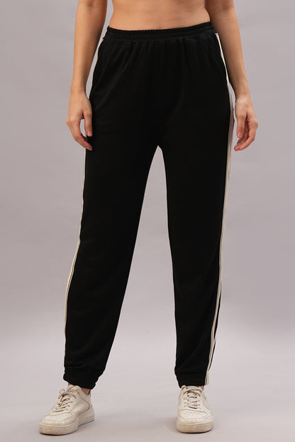Model in the Black Co-Ord Set stands on a gray background, pairing it with white sneakers for an effortlessly stylish and coordinated look.