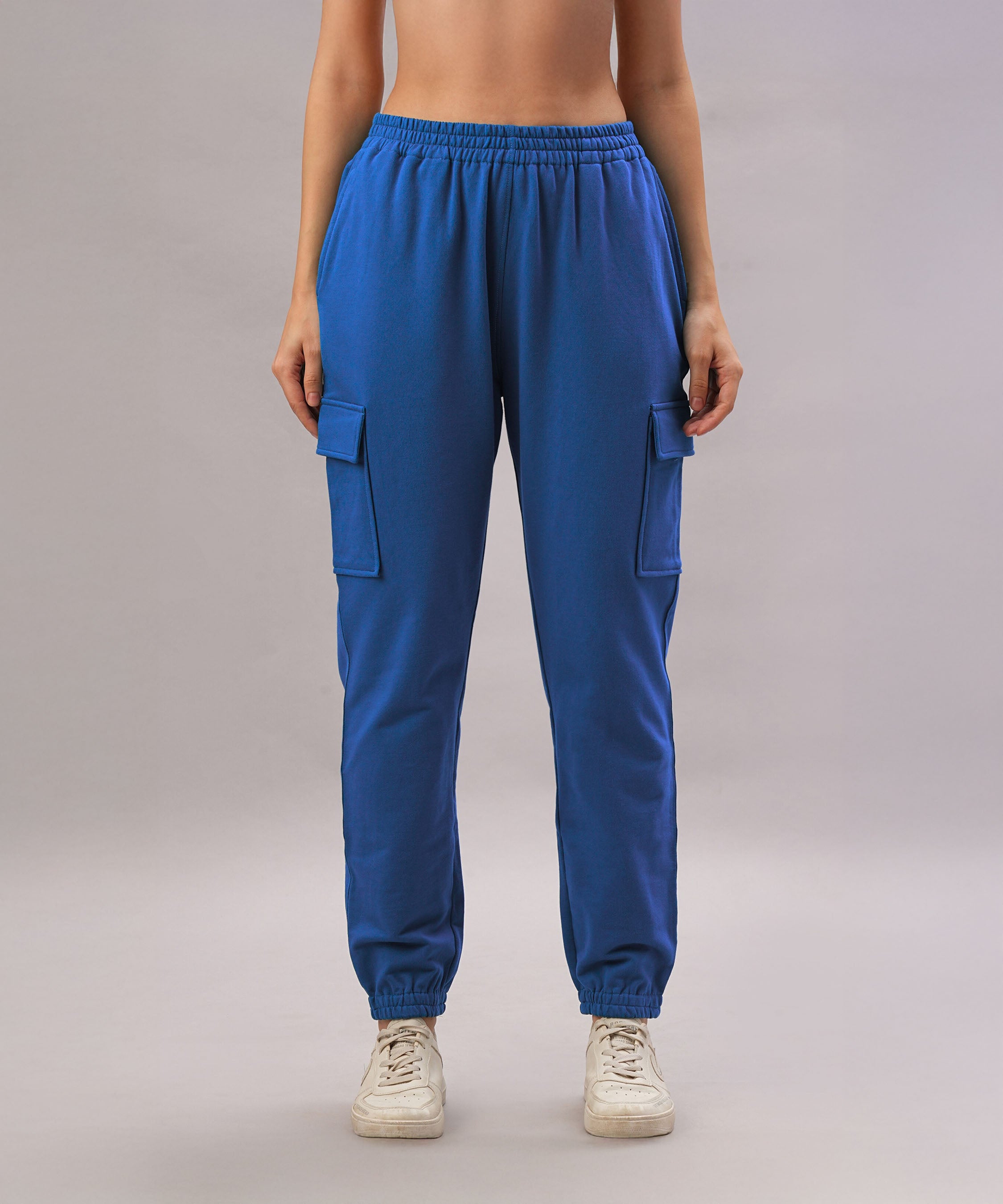 A person wears the Soft Royal Blue Trackset cargo-style joggers in a breathable cotton-viscose blend with white sneakers, standing against a plain background.