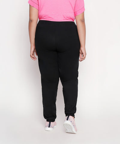 Model in a pink shirt and Classic Joggers - Plus Size 02, paired with pink sneakers, shown from the back against a plain background.