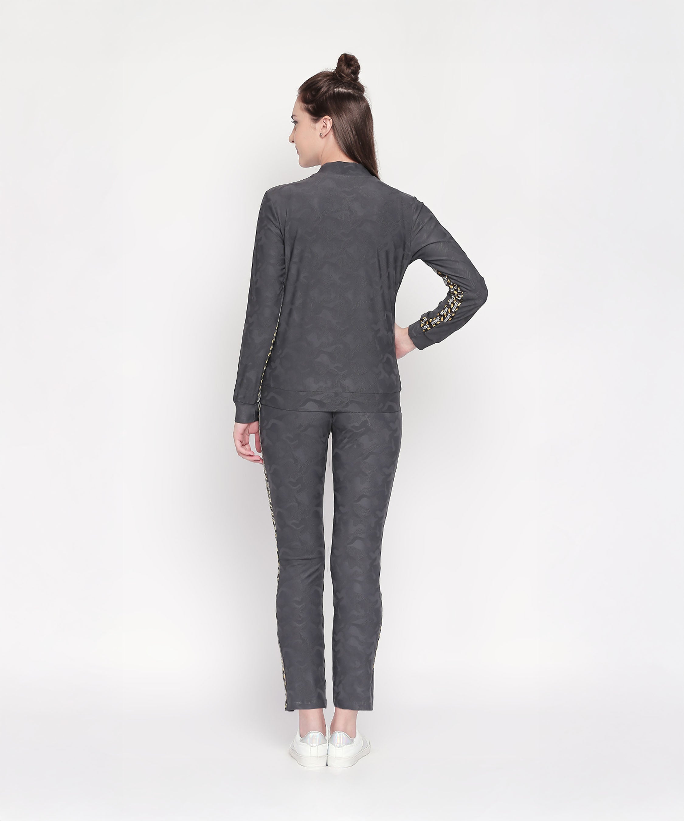 A woman wears the Camouflage Print Tracksuit, featuring a V-neck collar jacket and elasticated track pants.
