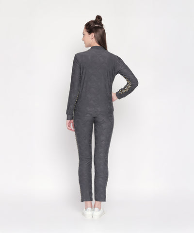 A woman wears the Camouflage Print Tracksuit, featuring a V-neck collar jacket and elasticated track pants.