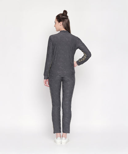 A woman wears the Camouflage Print Tracksuit, featuring a V-neck collar jacket and elasticated track pants.