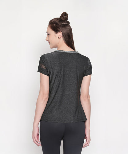 Woman with brown hair in a half-bun, facing away, wearing the Active Wear Top in Grey Color for Women and black leggings.