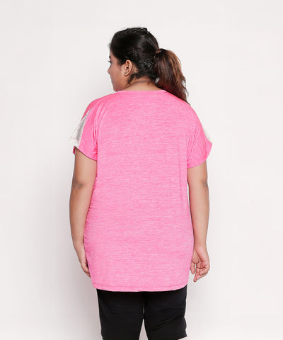 A woman, seen from behind, wears the Nova Sports Tee—a pink, short-sleeve performance top—paired with black pants, ideal for any workout wardrobe.