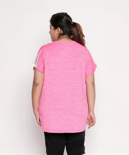 A woman, seen from behind, wears the Nova Sports Tee—a pink, short-sleeve performance top—paired with black pants, ideal for any workout wardrobe.