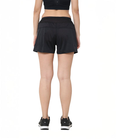 Model stands with her back to the camera in Black Shorts, on a white background. The athletic fit and breathable fabric ensure comfort during any activity.