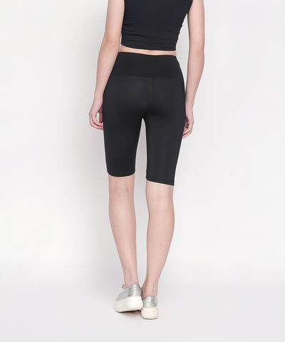 Person wearing a black crop top and Black Biker/Cycling Shorts with a high-rise waistband, standing with back to camera.