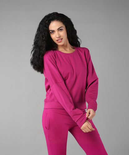 Woman with long curly hair wearing the Deep Pink Comfort Duo, standing against a plain gray background.