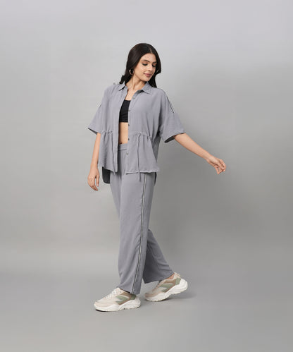 A woman wearing the Grey Tie Up Top with Loose Pants Cord Set and sneakers poses against a plain light gray background.