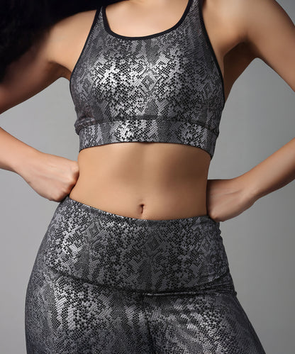 Woman wearing a Black Silver Shimmer Print Sports Bra and leggings, standing with hands on hips, ready for her workout.