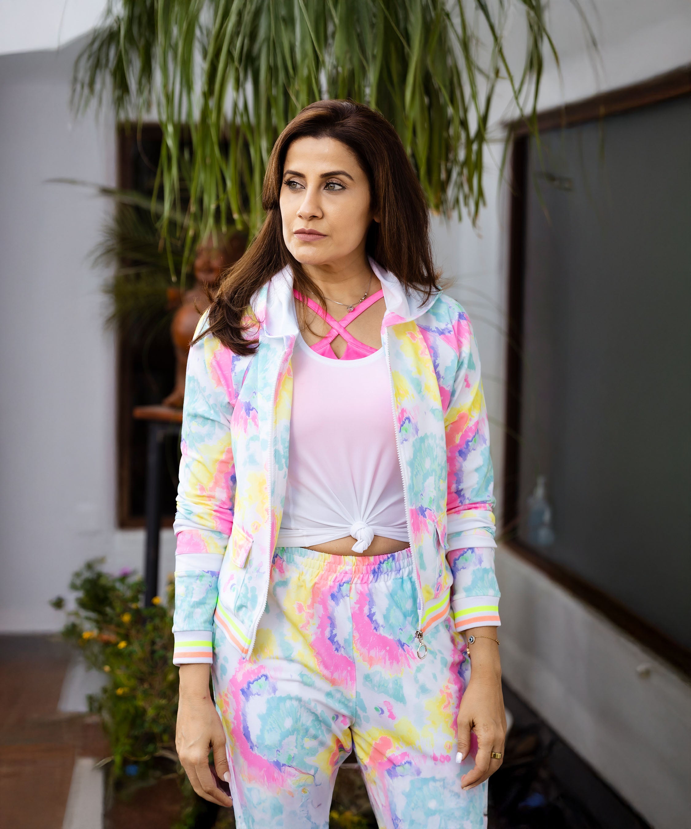 A woman in a Multicolour Neon Jacket & Joggers Set with cargo pockets stands outdoors, looking away with a neutral expression.